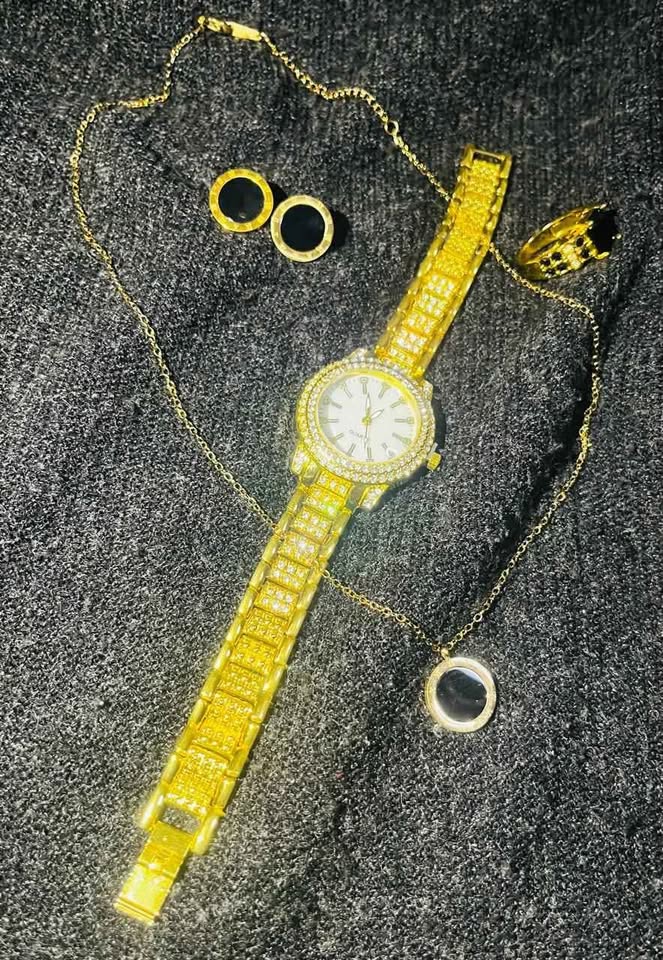 Conjunto de joyería incluye reloj, cadena con dije, anillo con piedra negra y par de aretes, acero inoxidable, color dorado