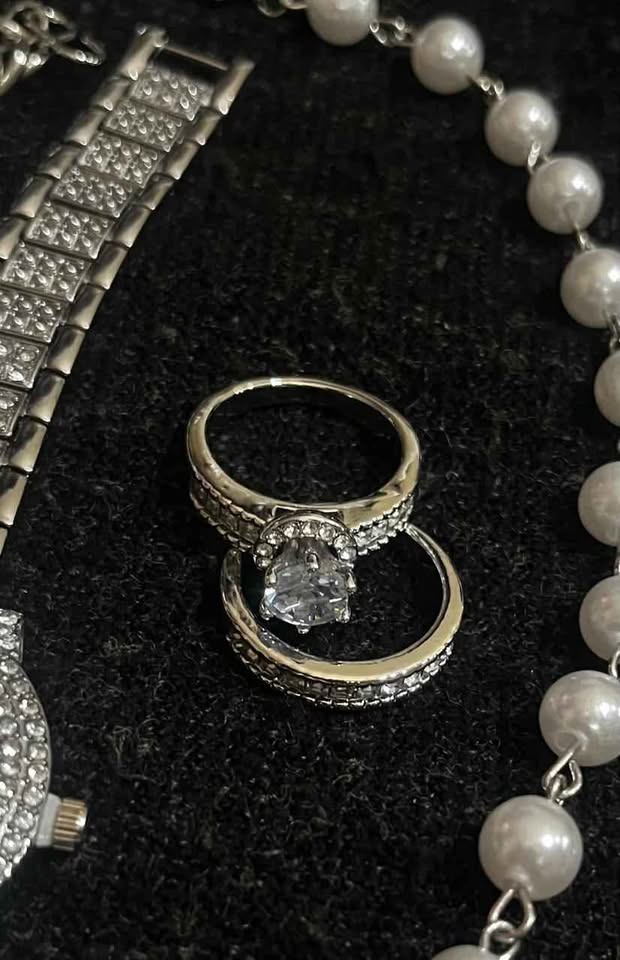 Conjunto de joyería color plata incluye reloj, cadena con perlas sintéticas y dije de corazón plateado, esclava de 8 mm de acero inoxidable y par de anillos de compromiso del numero 7