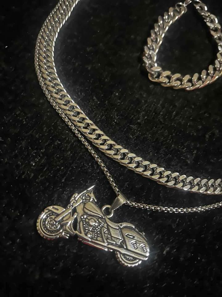 Conjunto de joyería incluye cadena con dije de motocicleta, cadena estilo cubano de 10 mm de ancho por 60 cms. de largo de acero inoxidable y esclava estilo cubana de 10 mm de ancho por 21 cms. de largo de acero inoxidable