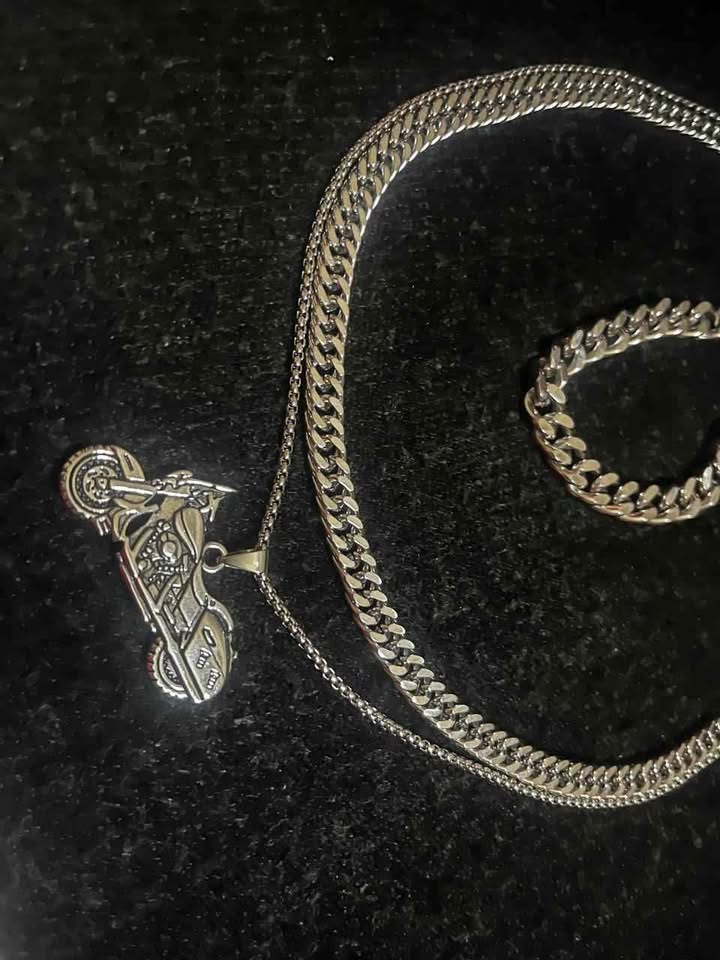 Conjunto de joyería incluye cadena con dije de motocicleta, cadena estilo cubano de 10 mm de ancho por 60 cms. de largo de acero inoxidable y esclava estilo cubana de 10 mm de ancho por 21 cms. de largo de acero inoxidable