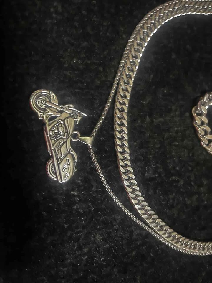Conjunto de joyería incluye cadena con dije de motocicleta, cadena estilo cubano de 10 mm de ancho por 60 cms. de largo de acero inoxidable y esclava estilo cubana de 10 mm de ancho por 21 cms. de largo de acero inoxidable