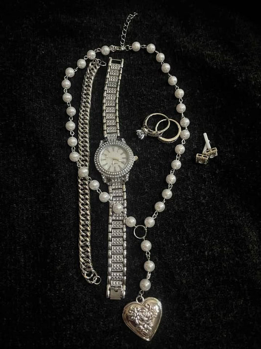 Conjunto de joyería color plata incluye reloj, cadena con perlas sintéticas y dije de corazón plateado, esclava de 8 mm de acero inoxidable y par de anillos de compromiso del numero 7