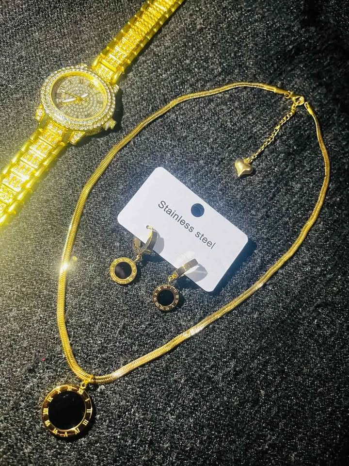 Conjunto de joyería incluye reloj, cadena con dije y par de aretes con detalle en color negro, acero inoxidable
