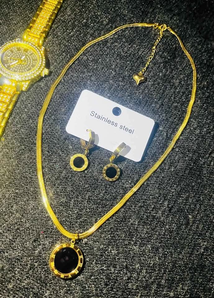 Conjunto de joyería incluye reloj, cadena con dije y par de aretes con detalle en color negro, acero inoxidable