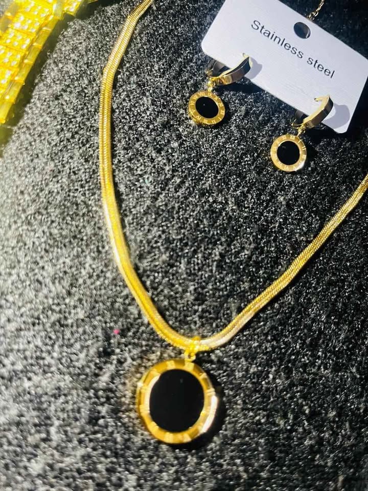 Conjunto de joyería incluye reloj, cadena con dije y par de aretes con detalle en color negro, acero inoxidable